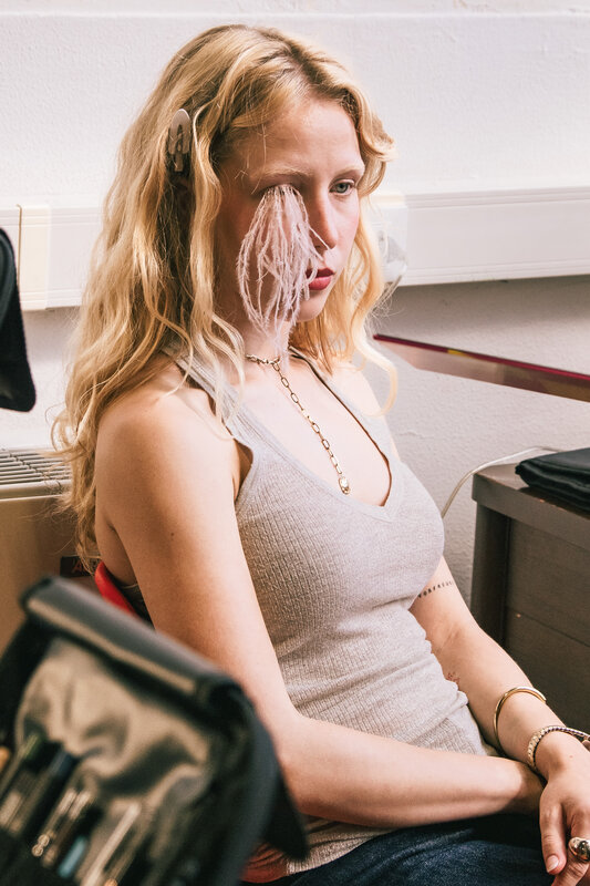Ragazza seduta nel backstage con un velo sul viso